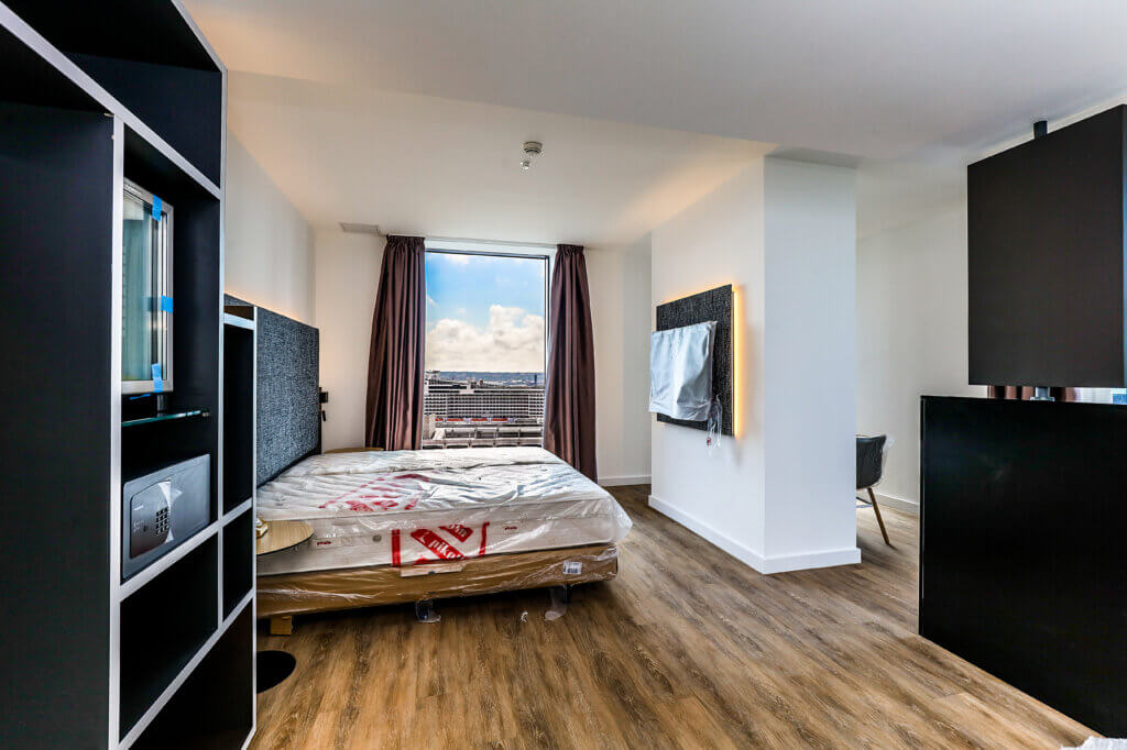 Liverpool Echo bedroom. Fitted with shelves, floating bed, TV, mini fridge and seating area